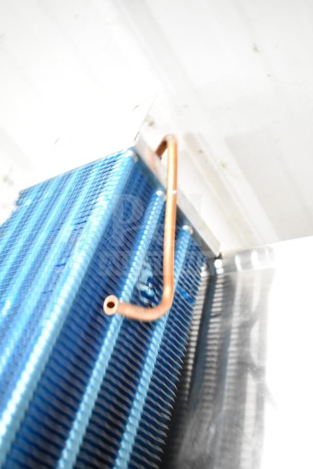 Blue evaporator coil with copper tubing, shown vertically against a white background, in good condition.