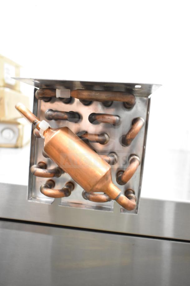 Copper evaporator coil with a series of curved tubes and a cylindrical component, in good condition, ideal for HVAC systems.