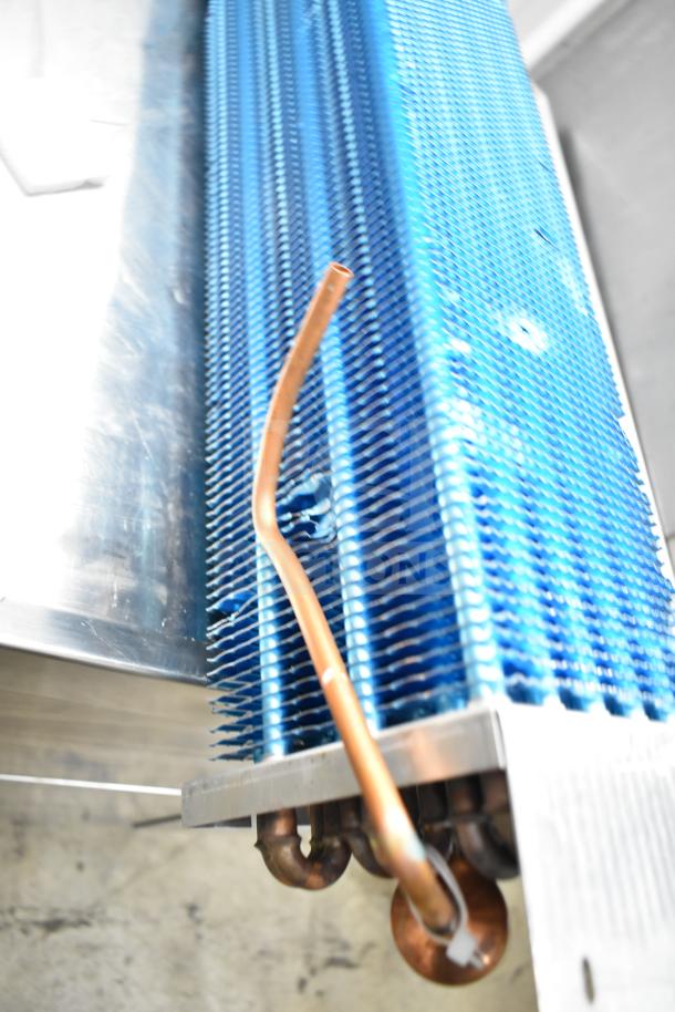 Blue evaporator coil with visible copper tubing, in good condition. Ideal for HVAC systems. No visible labels or markings.