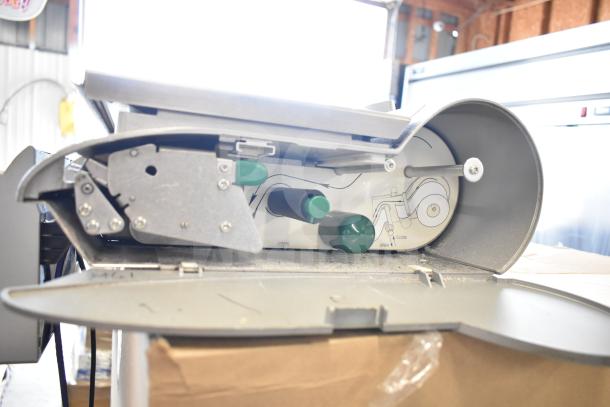 Mettler Toledo countertop food portioning scale, tested and working. Features durable metal construction, visible open/close mechanism, and green adjustment knobs.