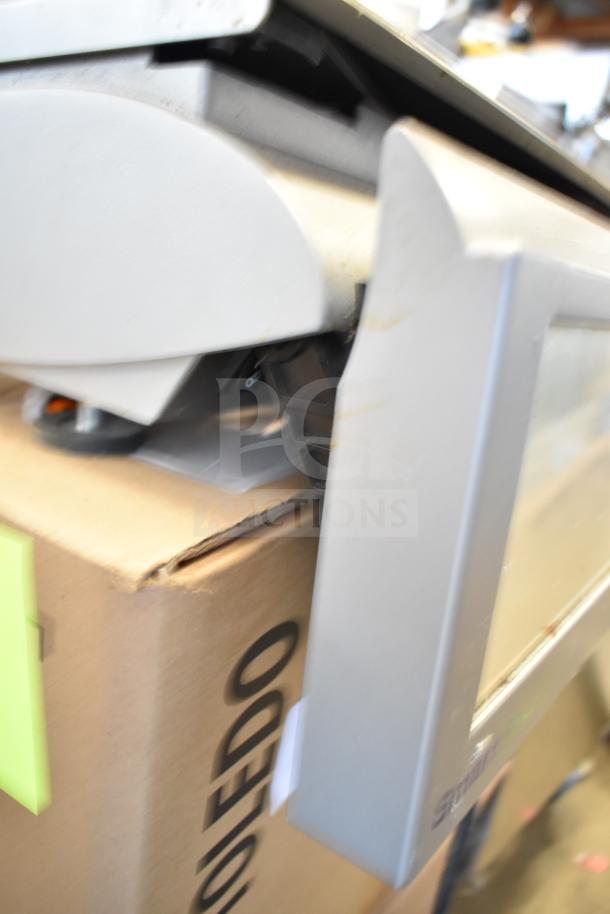 Mettler Toledo countertop food portioning scale, tested and working, without power cord. Visible branding on cardboard box.