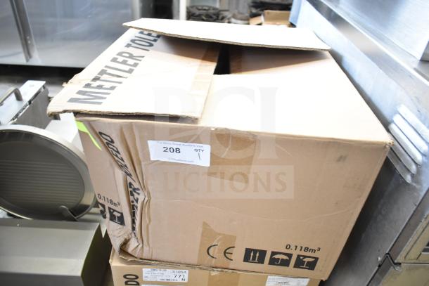 Mettler Toledo countertop food portioning scale in a box, no power cord, untested and does not power on. Box shows some wear.