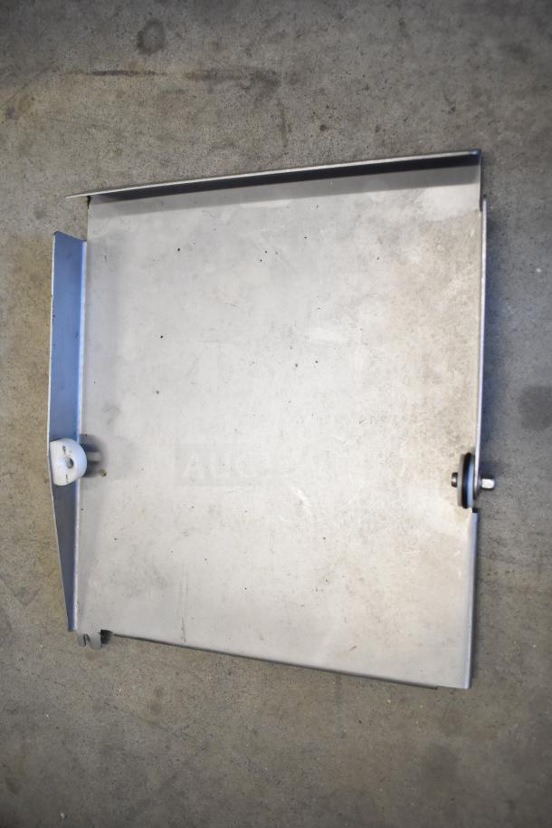 Scharfen VA2000 GR meat slicer stacker metal component plate on concrete background. Visible wear and mounting hardware.