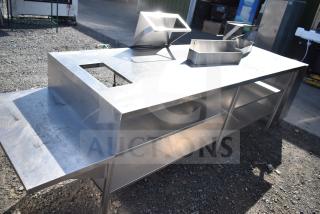 Stainless steel commercial table with two under shelves, featuring a cutout section and a side extension.