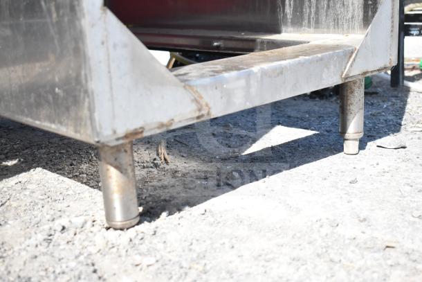 Southern Stainless Equipment Co counter with 2 red doors, stainless steel, visible wear and rust on legs.