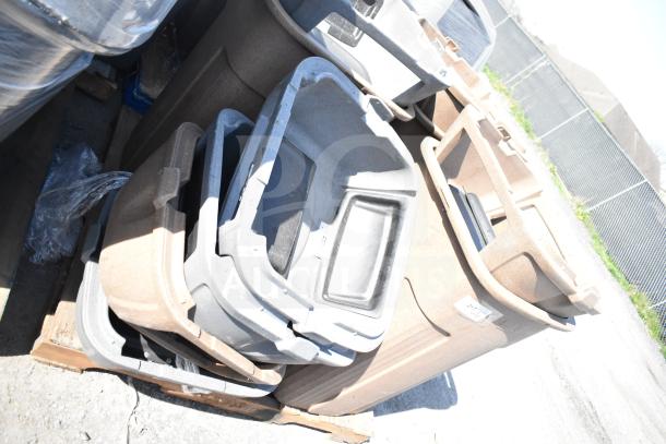 Three poly trash cans with extra lids, stacked on a pallet. Used condition, various colors, ideal for bulk bidding.