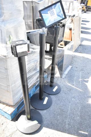 Three black stanchions with round bases, in used condition. Each has a retractable belt. Label reads "224."