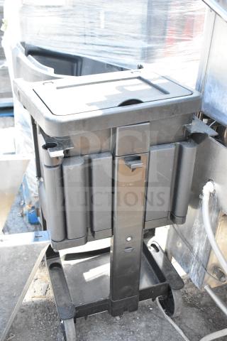 Rubbermaid black poly janitor cart on casters, sturdy design, with storage compartments, in good used condition.