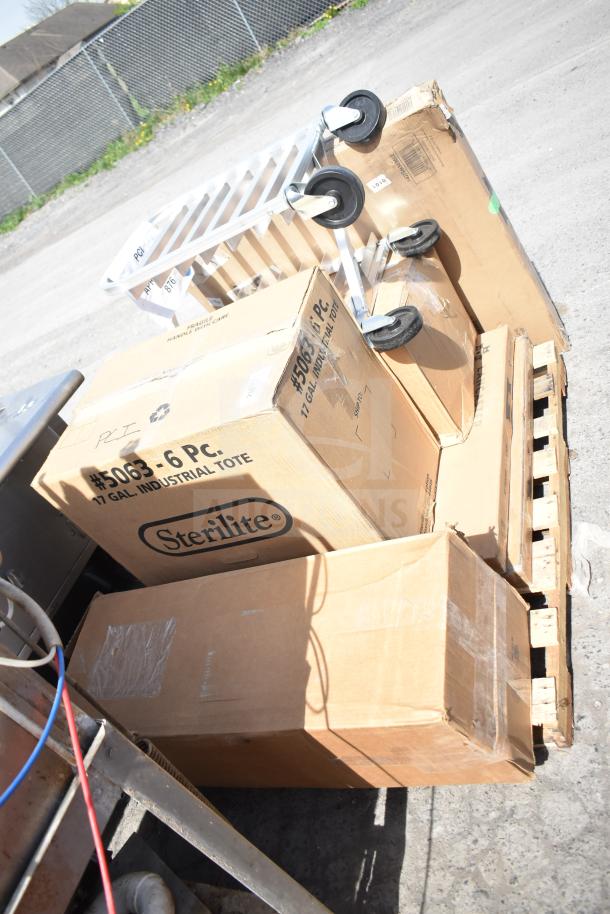 Various brand new items including a Sterilite storage tote and pan rack in boxes, some scratch and dent, on a pallet.