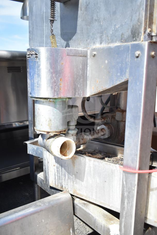 CMA AH-2 commercial pass-through dishwasher in used condition. Visible components and metal frame show wear and rust.