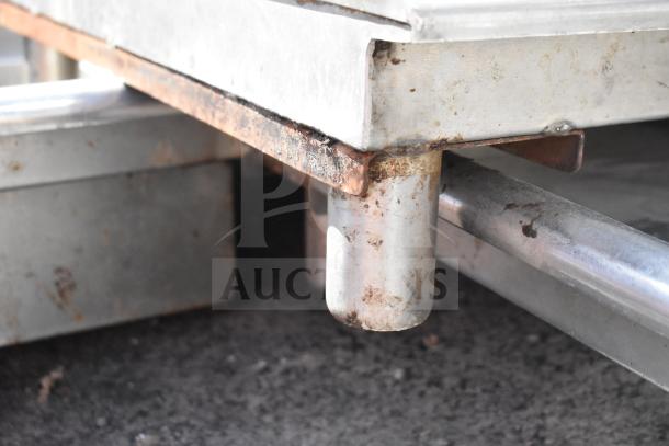 Left side clean dishwasher table, no legs, shows metal surface with visible rust and wear. Suitable for commercial use.