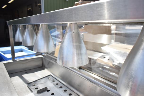 Commercial hot food merchandising case with stainless steel finish, heating lamps, and a transparent display section.