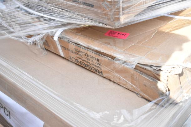 Cardboard boxes containing brand new scratch and dent items, including a table, strip warmer, and pan rack, wrapped in plastic.