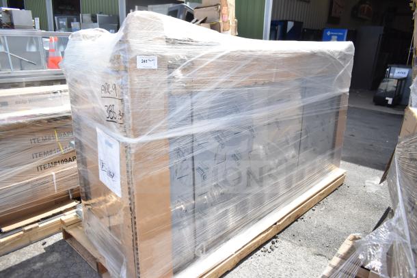 Alt text: Large boxed item wrapped in plastic sheeting on a pallet, marked "Scratch and Dent." Shipping labels and markings visible.