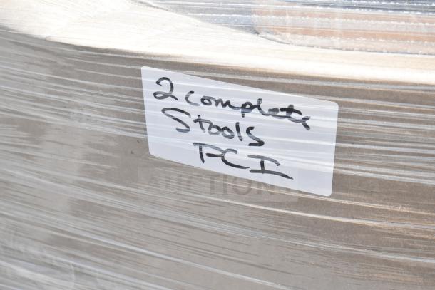 Pallet wrapped pack labeled "2 complete stools, PCI," showing new scratch and dent furniture items.