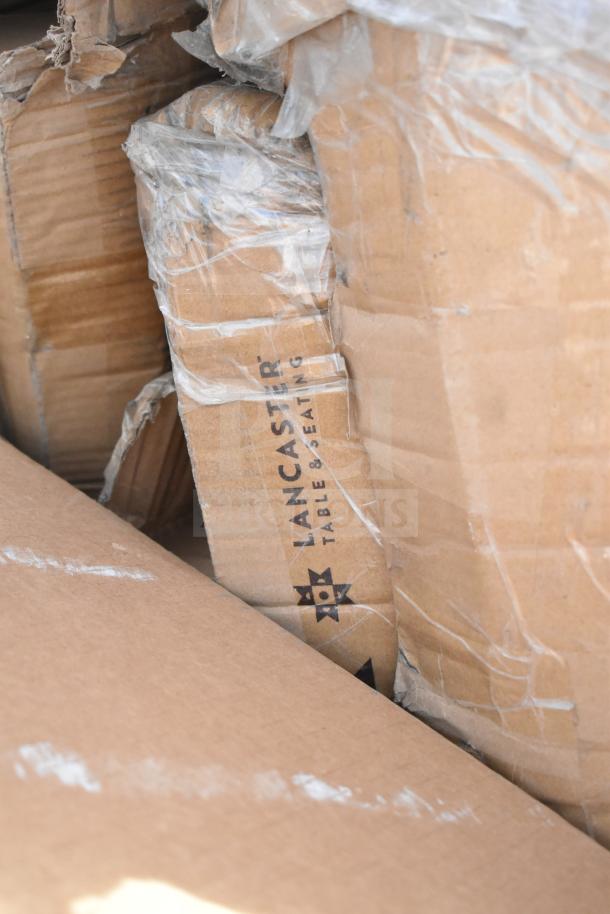 Cardboard packages of brand new Lancaster tables and chairs, visibly dented, wrapped in plastic.