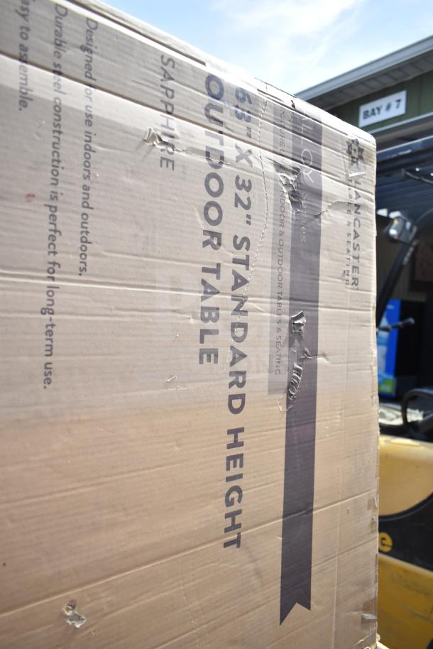 Cardboard box labeled "63'' x 32'' Standard Height Outdoor Table," showing scratches and dents, indicating new but imperfect condition.