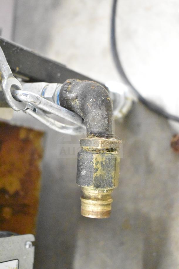Alt text: Close-up of a connection joint and pipe fitting on a 2023 Henny Penny 600 commercial pressure fryer.