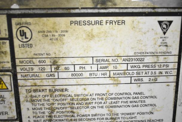 2023 Henny Penny Model 600 pressure fryer label. Gas-powered, 80,000 BTU, serial AN2310022. UL listed, ANSI certified.