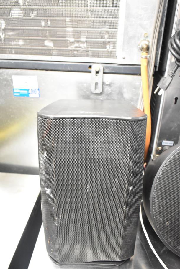 QSC AD-S6T speaker with metal grille, minor scuffs visible. Part of an auction with 7 Crestron SAROS PD6T-B-T-EACH speakers.