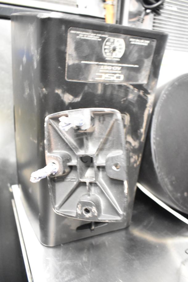 QSC AD-S6T speaker with scuffed surface, visible mounting bracket, and label. Includes 7 Crestron SAROS PD6T-B-T-EACH speakers.