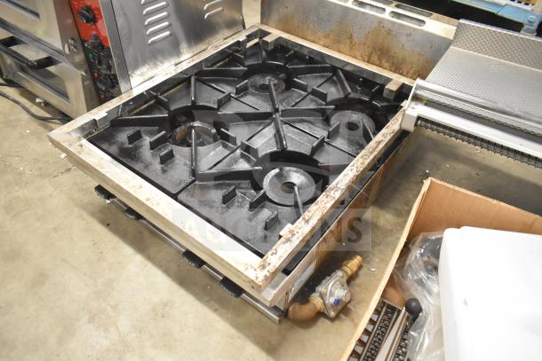 Commercial countertop natural gas 4 burner range, used condition, black cast iron grates, visible rust on frame, operational knobs.