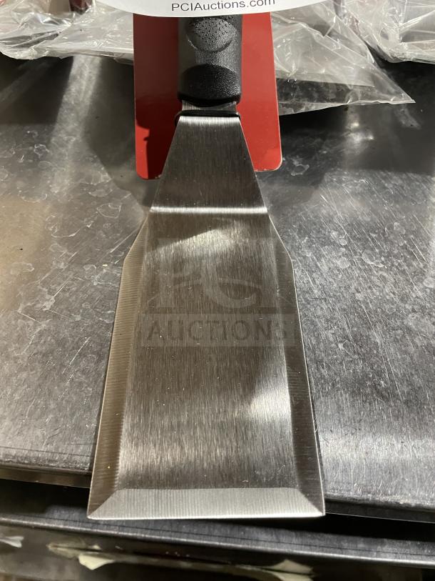 Brand new Winco TKP-61 hamburger turner, stainless steel, commercial-grade, ergonomic handle, tag shows model and condition.