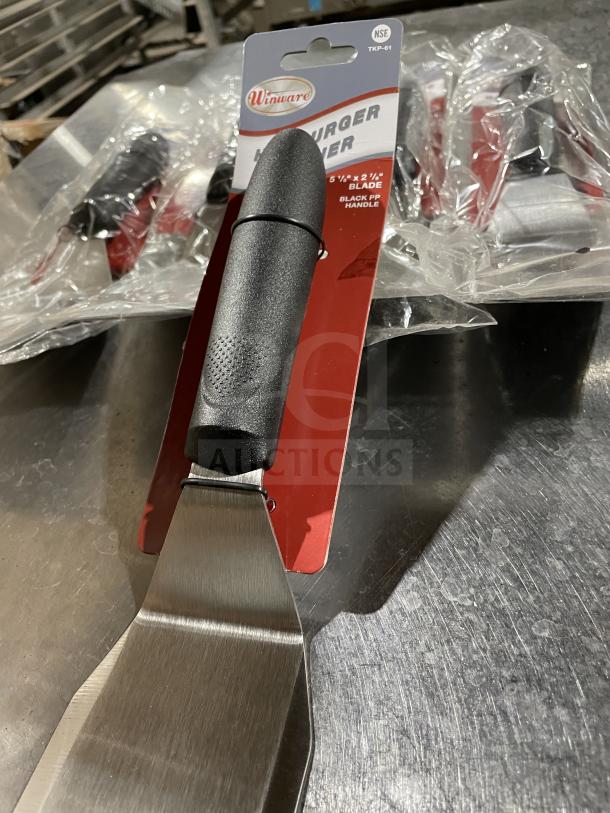 Brand new Winco Winware Series hamburger turner, model TKP61. Stainless steel blade, black PP handle, in packaging.