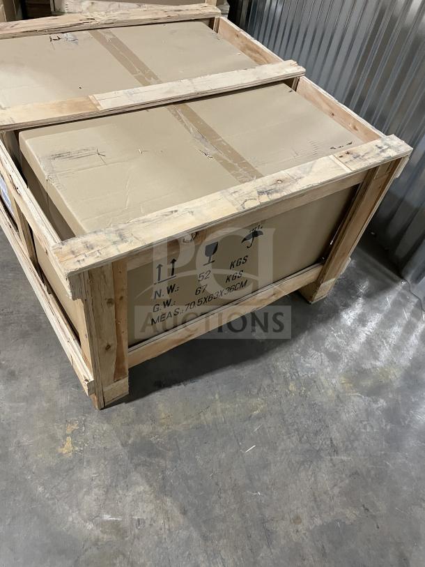 Crate containing a Cookline CGG24M stainless steel gas griddle, brand new, with back and side splash and manual controls.