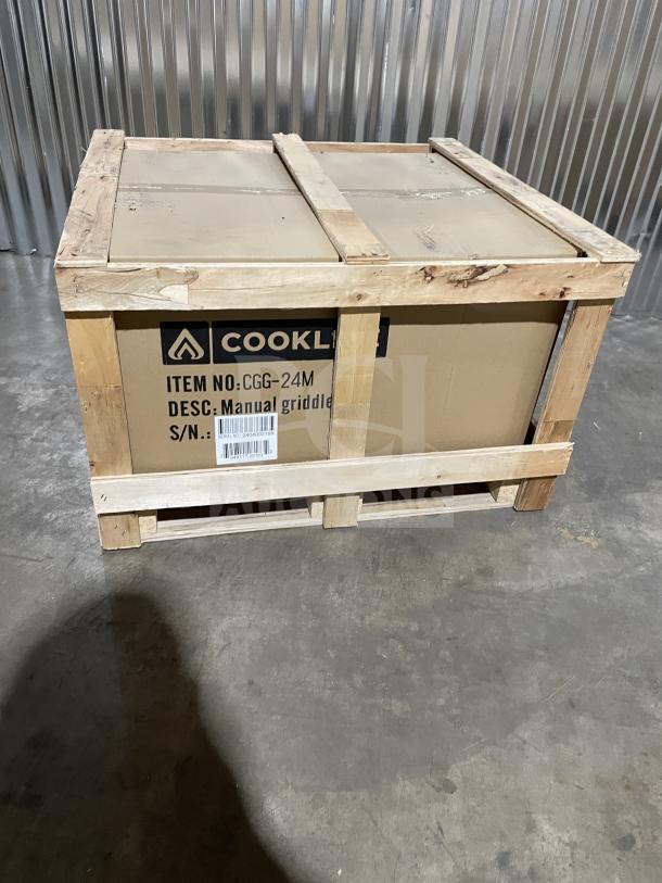 Cookline CGG24M griddle in a wooden crate. Brand new, manual controls, stainless steel, gas-powered, with splash guards.
