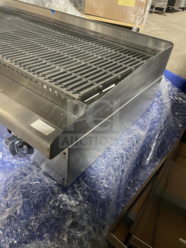 Brand new Star Max Series stainless steel gas countertop radiant char broiler with cast iron grates, back and side splash.