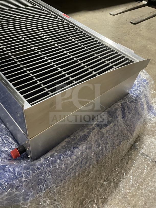 Brand new Star Max Series stainless steel gas char broiler with cast iron grates, back and side splash, on legs.