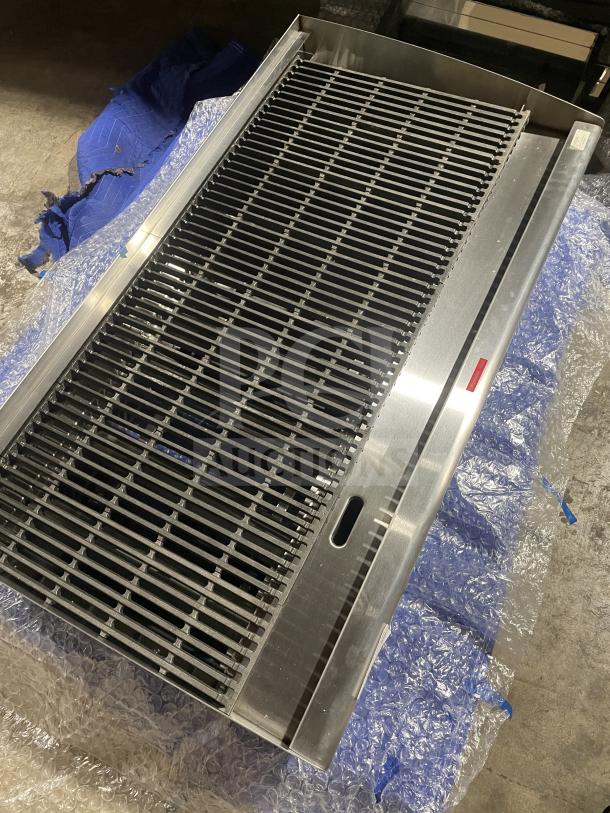 Brand new Star Max Series stainless steel gas countertop char broiler with cast iron grates, back and side splash, on legs.