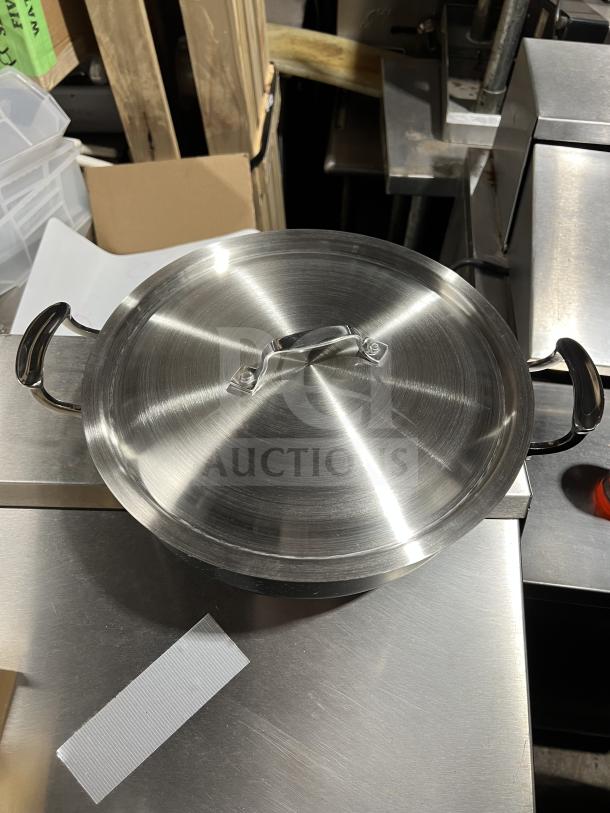 Brand new Bon Chef 6 Qt black saute pot with stainless steel lid, interior, and handles, in original packaging.