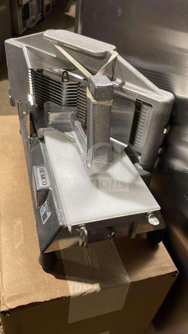 Brand new Nemco 55600-1 commercial countertop tomato slicer with 3 1/16" stainless steel blades, on legs.