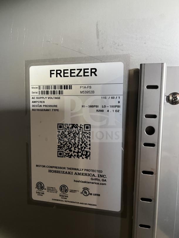 Hoshizaki F1A-FS stainless steel one-door freezer, new, with wired racks. Label shows: 115V, SN: M53952B, R290 refrigerant.