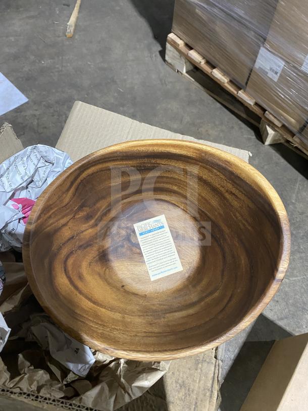 Acacia wood bowl with Pacific Merchants tag, resting on cardboard packaging.