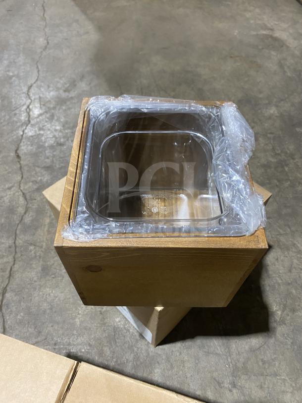 Brand new Cal-Mil bamboo ice housing unit inside a wooden frame, wrapped in plastic, on a warehouse floor.