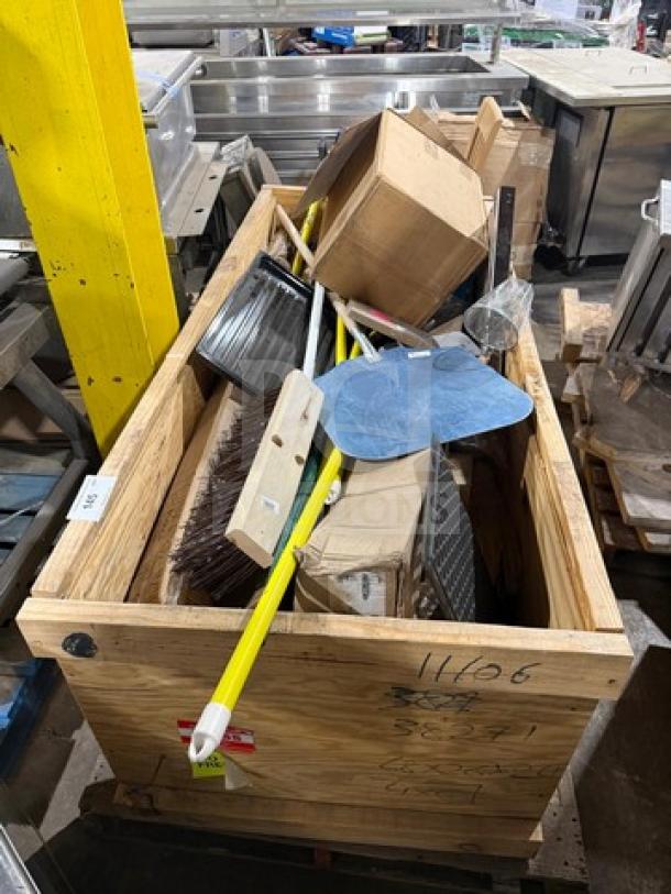 Crate full of miscellaneous restaurant ware including brooms, mop sticks, pizza peels, and boxes in new condition.