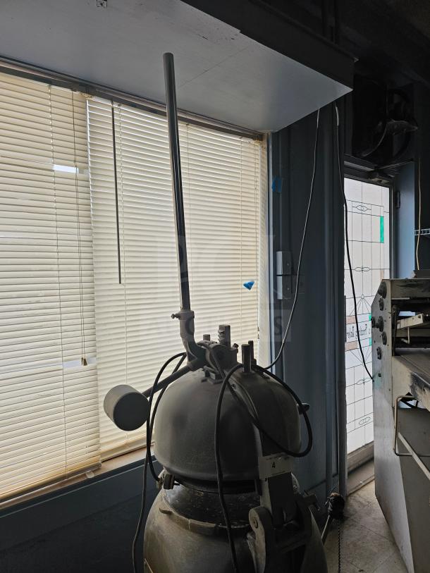 Commercial dough divider machine with metal construction, visible wear. Features levers and a control panel, suitable for bakery use.