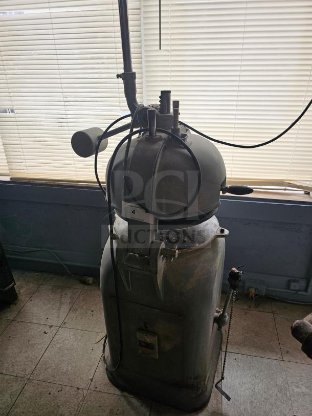 Commercial dough divider in used condition, featuring a cylindrical metal body with control levers and visible wiring.