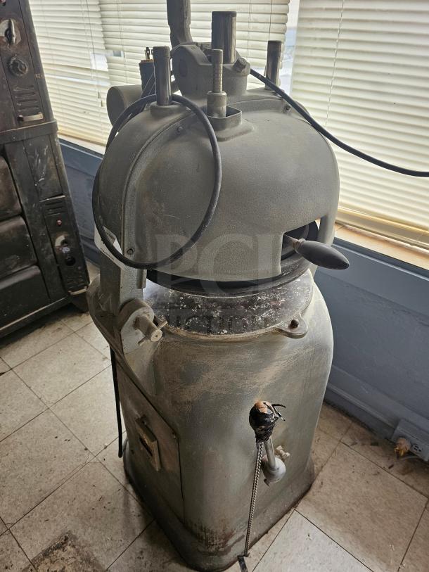 Commercial dough divider machine, vintage model, shows signs of wear and rust, manual operation, industrial-grade construction.