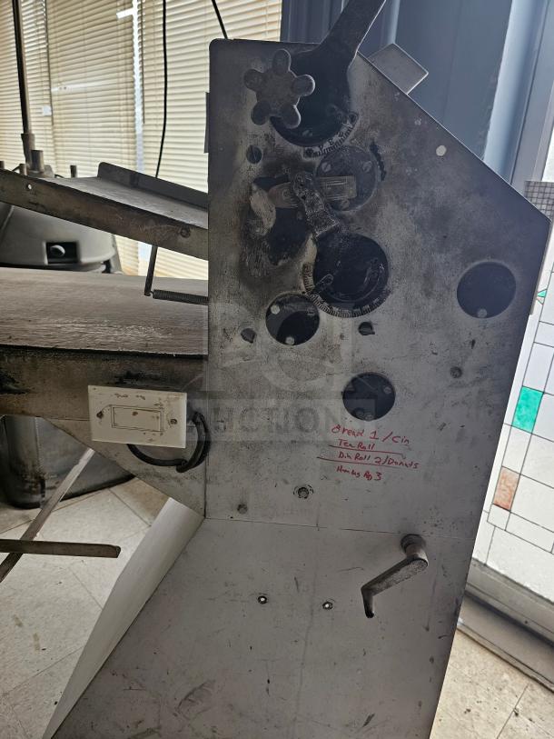 Commercial dough sheeter in used condition, right side view showing control levers and handwritten settings details.