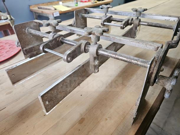 Commercial dough sheeter, metal construction, adjustable rollers, visible wear, suitable for bakery use.