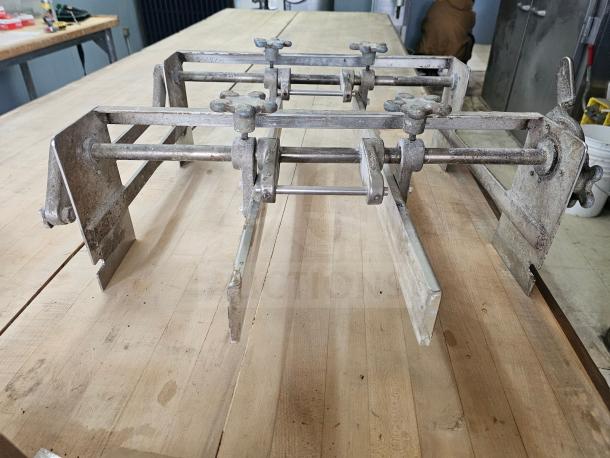 Commercial dough sheeter with metal frame and adjustable rollers. Moderate wear. Ideal for bakery use; no visible brand markings.