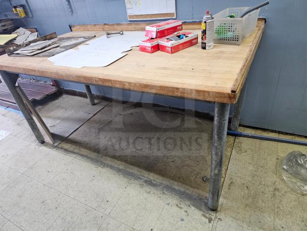 Wood top work table with metal legs, sturdy construction, natural finish, used condition, approximately 6 feet long.