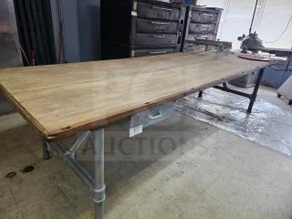 12Ft wood top work table with a sturdy metal frame. Features include signs of light wear, a side drawer, and a durable surface.