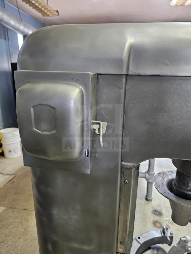 Hobart 60Qt commercial mixer in used condition, includes attachments. Durable metal body with control mechanisms visible.