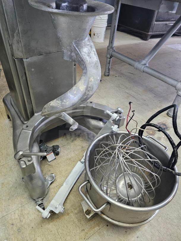 Hobart 60Qt Commercial Mixer with attachments including whisk and dough hook, used condition. Stainless steel bowl included.