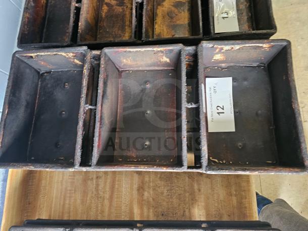 Metal baking pan with worn, rustic finish, featuring rectangular compartments. Auction label indicates lot number 12.